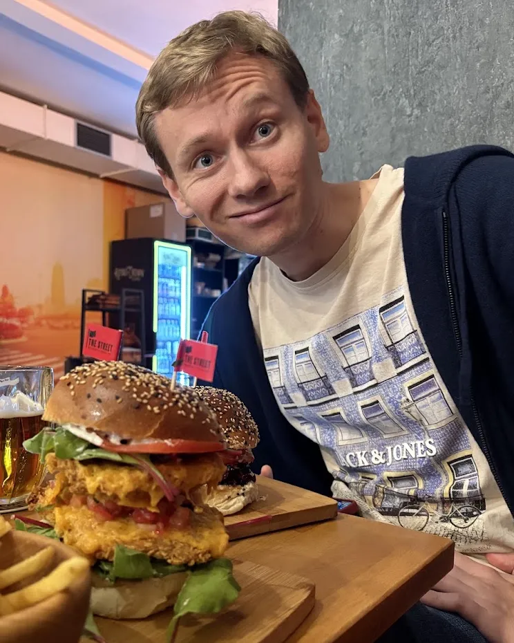 Olof at a restaurant with a tall burger in front of him.